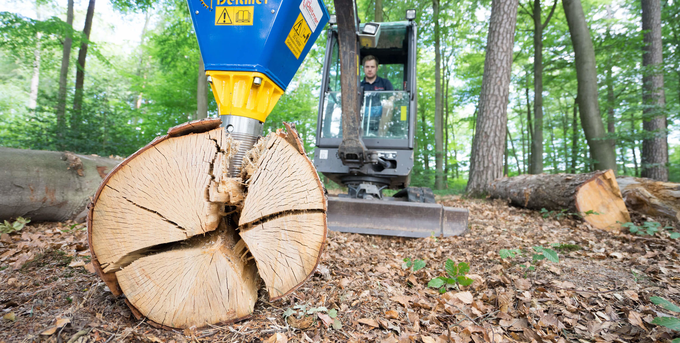 Herr Deitmer arbeitet mit einem Minibagger, an dem ein Kegelspalter montiert ist.
